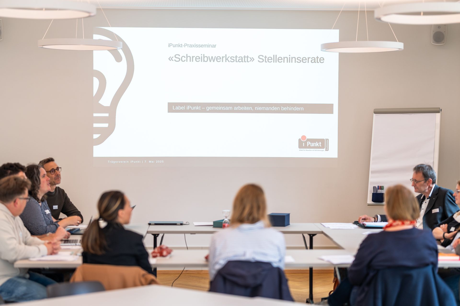 Mehrere Teilnehmende, die in einer Runde sitzen.