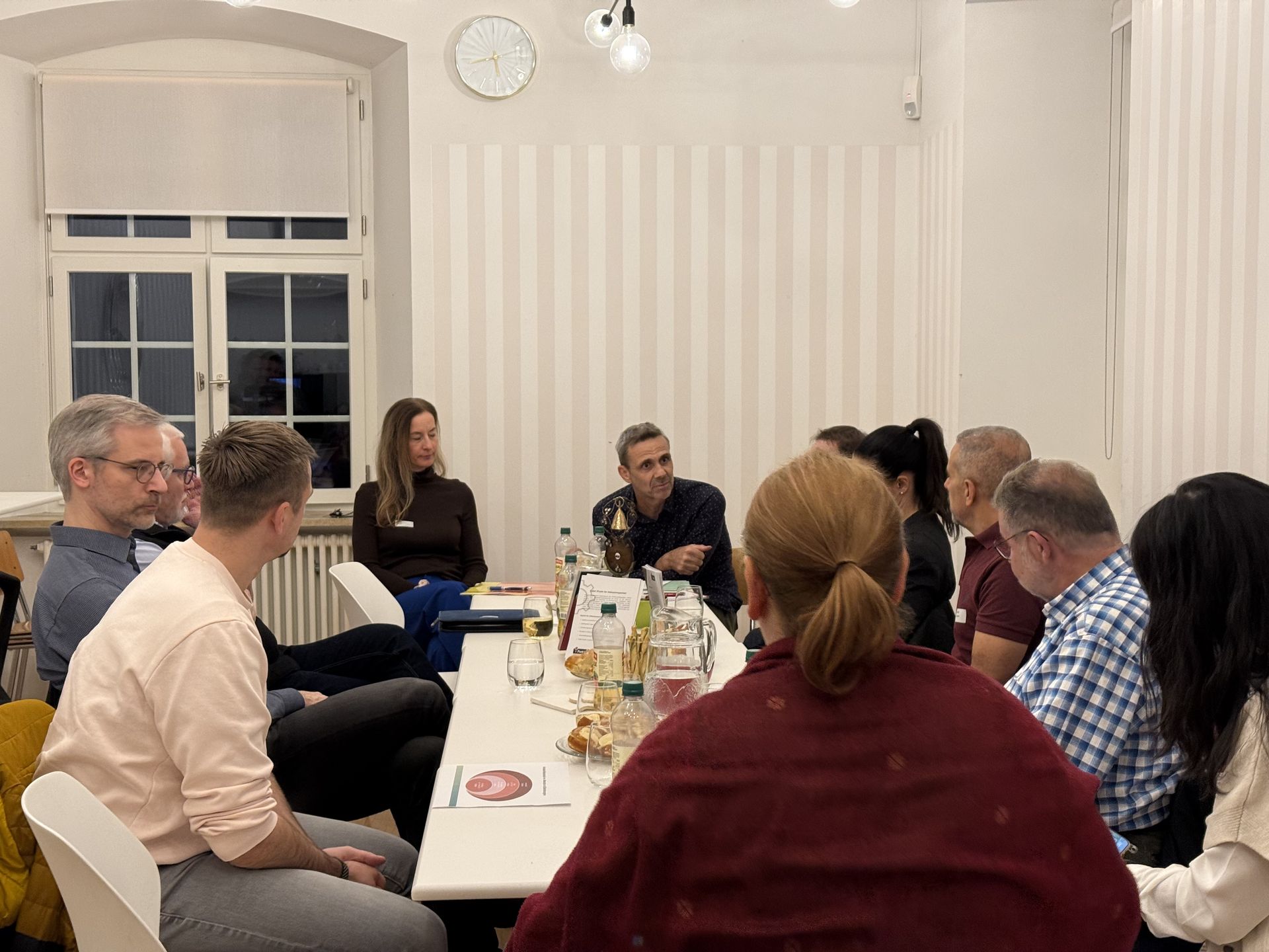 Teilnehmende des iPunkt-Stammtischs sitzen gemeinsam an einem Tisch in der Gemeindeverwaltung Arlesheim und tauschen sich über den Arbeitsplatzerhalt aus.